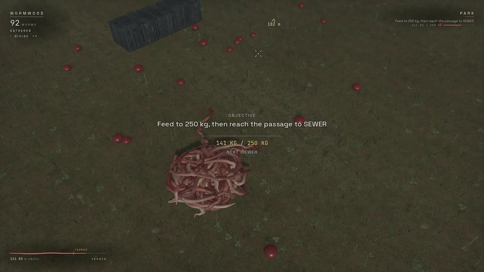 WORMWOOD prototype: a knot of red worms on a park lawn, the objective reading feed to 250 kilograms